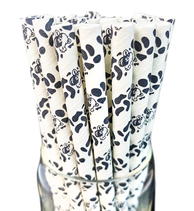 White straws with black animal print in a glass container on a white background