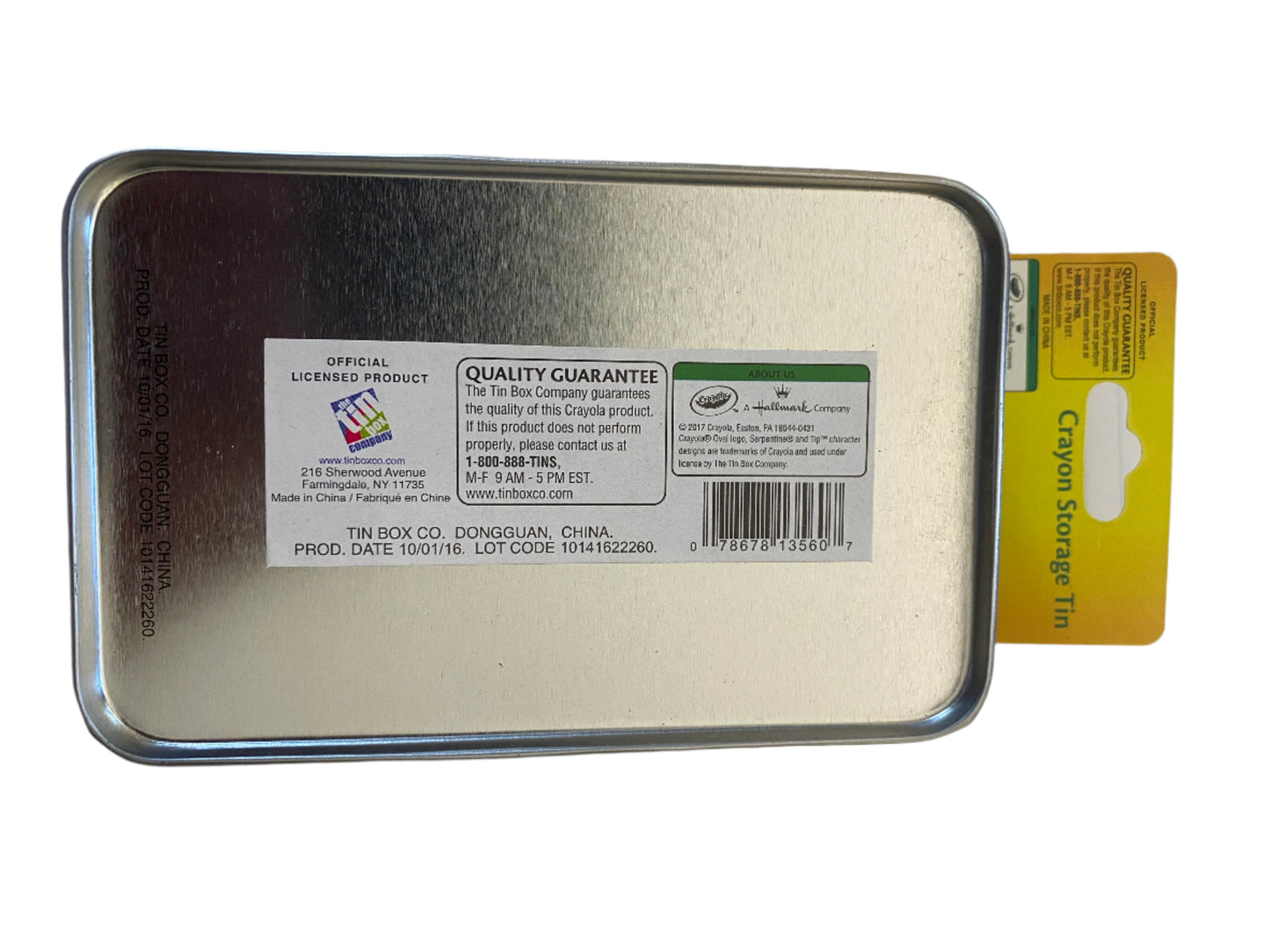 Metallic crayon storage tin with labels on a lined paper background